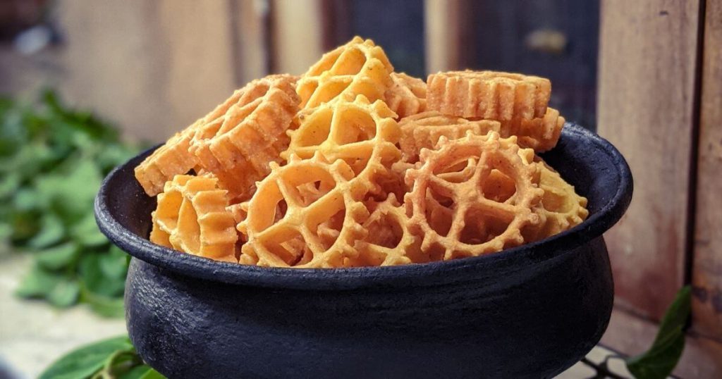 這張照片呈現了一碗金黃酥脆的Kokis,這是一道用油炸製作的斯里蘭卡傳統小吃,擺放在黑色的碗中,顯得質樸又美味。