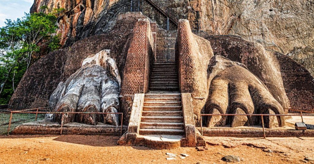 這張照片展示了著名的錫吉里耶岩石要塞的獅爪階梯入口。這個階梯通向位於錫吉里耶的古代城堡遺址,兩側是形狀如獅爪的石雕,象徵著王權和力量。錫吉里耶是斯里蘭卡的重要文化遺產,吸引了眾多遊客前來參觀。階梯通向頂部的古老遺址,當年是國王的宮殿所在地。