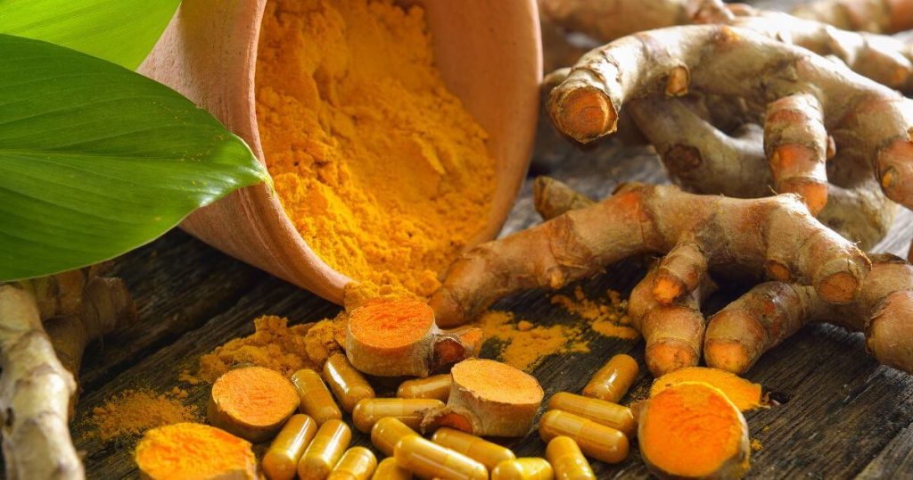 這張圖片展示了切開的薑黃根與灑出的薑黃粉，象徵其抗氧化與健康益處。