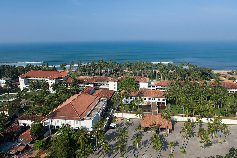 從高空俯瞰,這家位於加勒的飯店周圍環繞著棕櫚樹和海灘,紅瓦屋頂的建築物與蔚藍的海岸線形成鮮明對比。