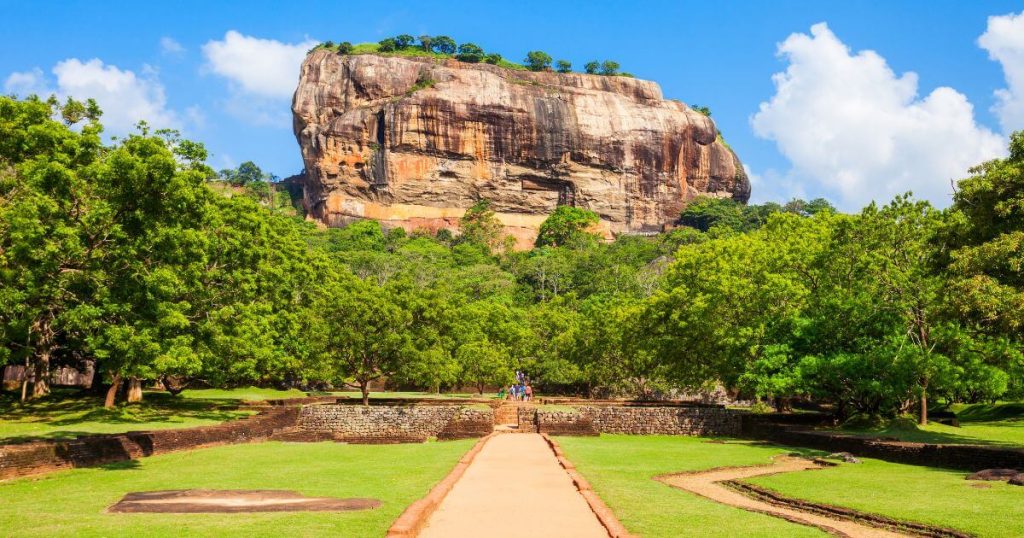 斯里蘭卡著名的獅子岩,壯麗的山岩結構在藍天白雲下顯得格外宏偉,是當地著名的歷史遺址。