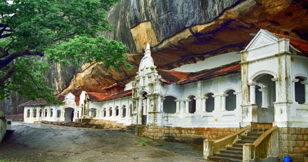 丹布勒石窟寺坐落於斯里蘭卡,是一座位於山巖中的佛教寺廟,擁有白色建築與壯觀的山岩背景,展示出歷史悠久的宗教建築風貌。