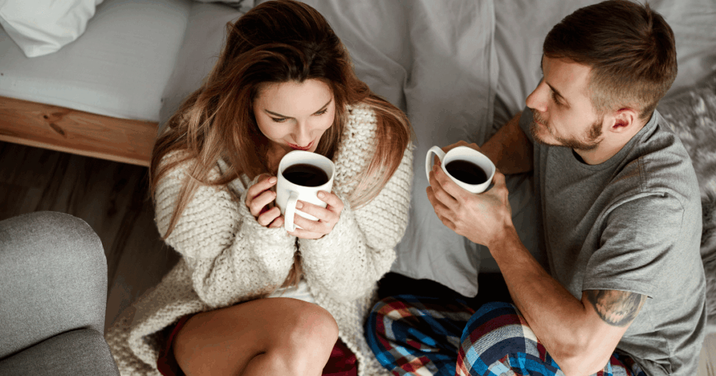 一對情侶坐在床邊對話，手中捧著咖啡，氛圍親密自然，展現互動與交流的溫暖片刻。畫面傳達愛情中溝通與陪伴的重要性，適合作為兩性關係、情感交流或旅遊浪漫氛圍的插圖。